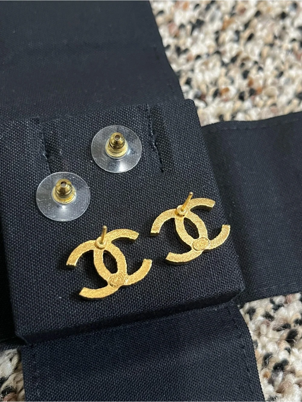 CHANEL Gold Interlocking CC Stud Earrings on Black